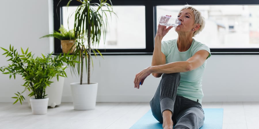 Frau trinkt beim Sport Wasser